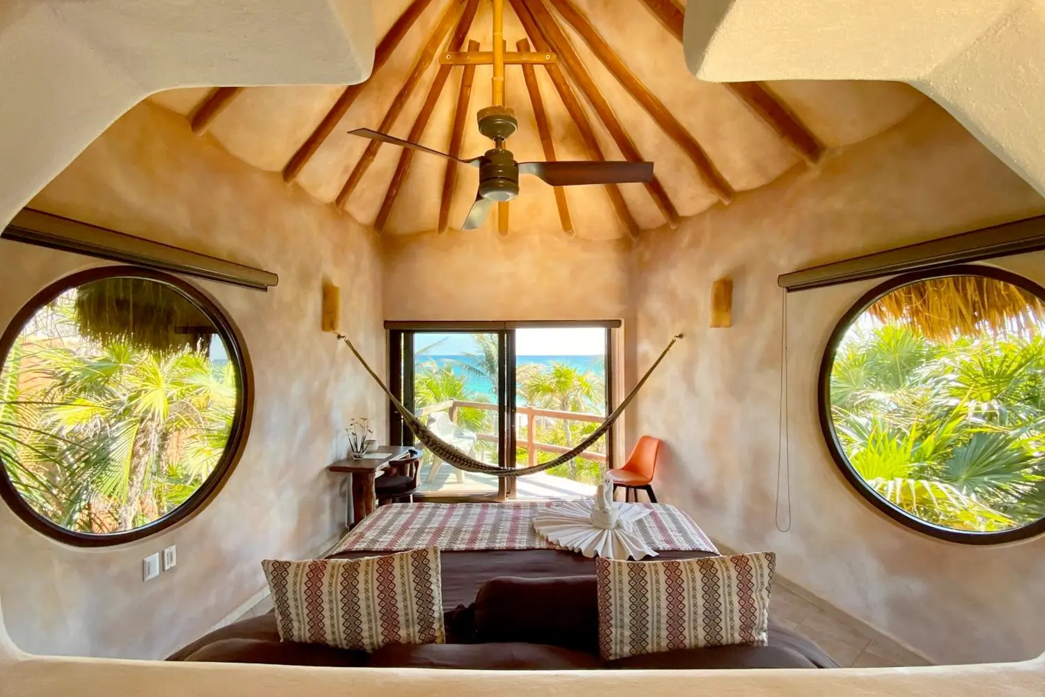 A room with a bed, windows, a hammock and a balcony with a view at Sueños Tulum