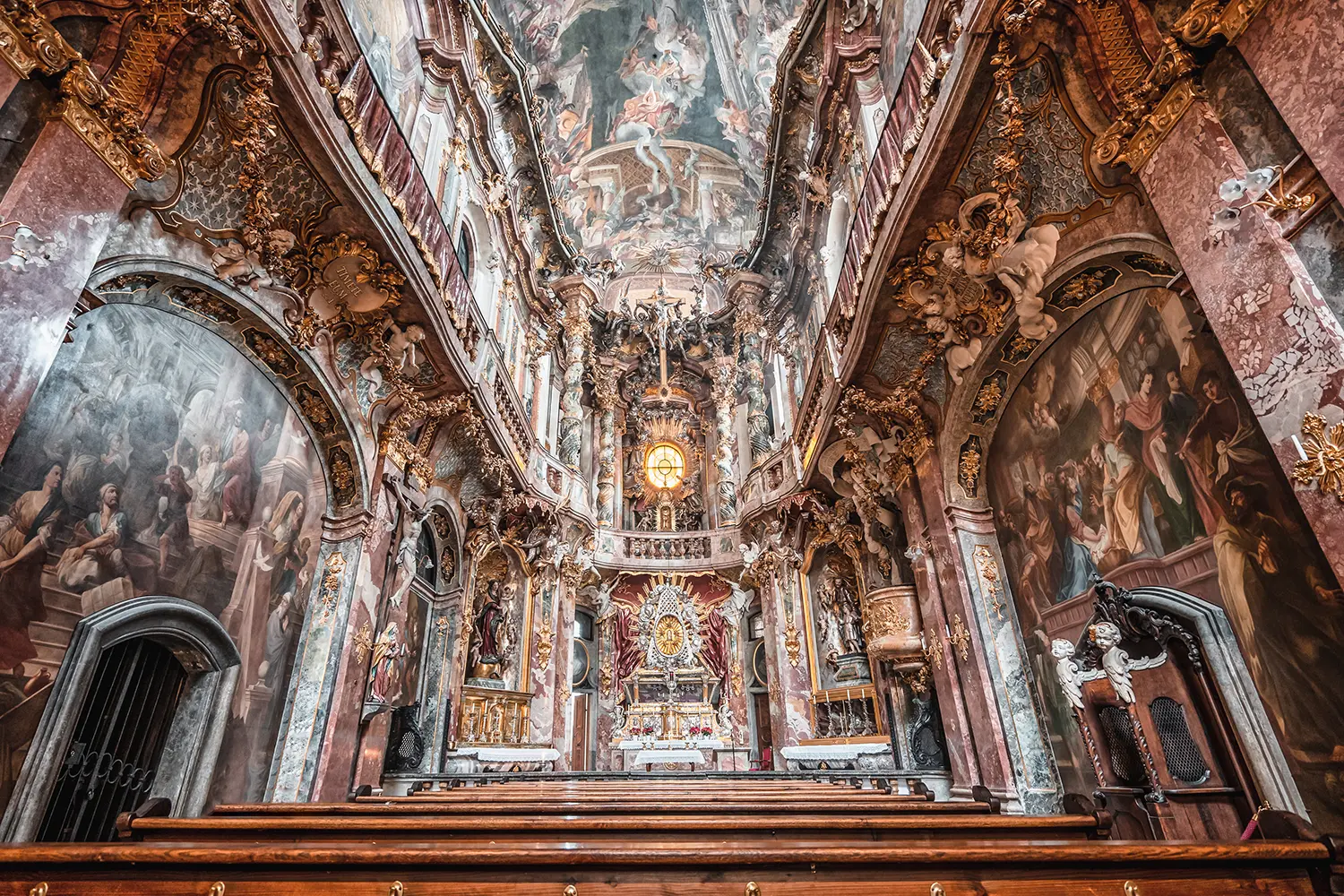 Interior of Asamkirche baroque church with altar and ceiling view in Munich
