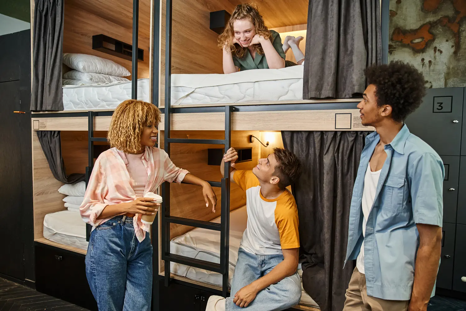 Travelers in the dorm room at a hostel socializing