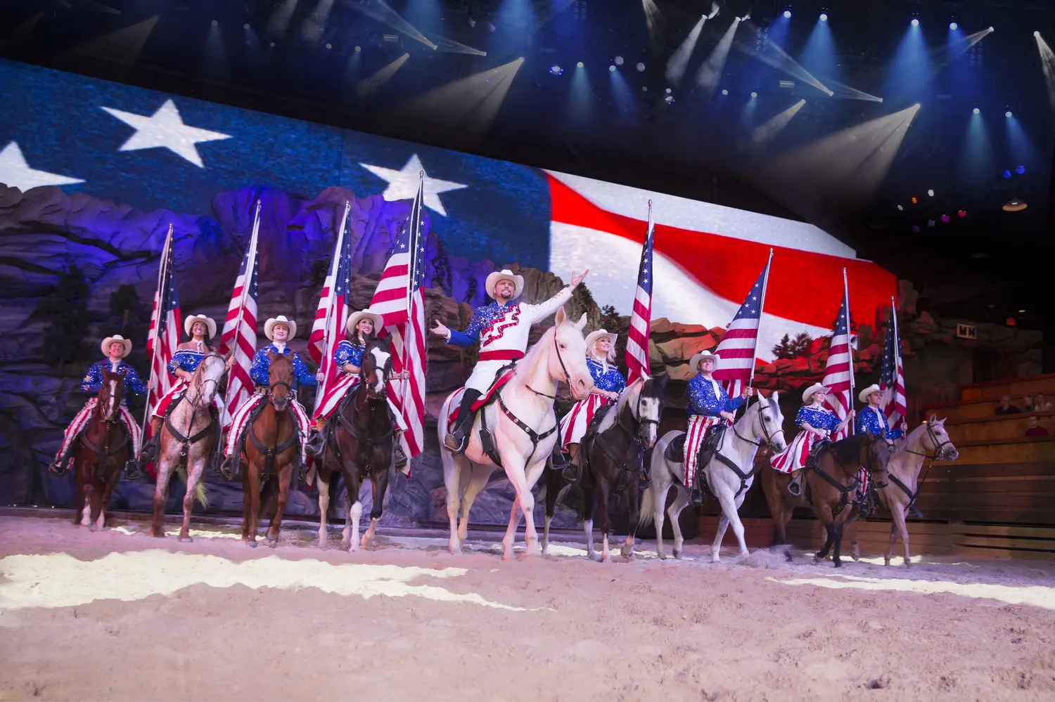 Performers on horses holding the USA flag at the Dolly Parton Stampede show in Branson, MO.